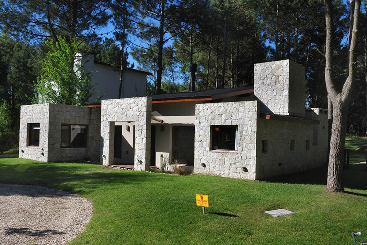 Fachada de casa moderna de pedra em floresta — projeto Casa Cariló 2006, por Hugo Zawadski Arquitectos, em Cariló