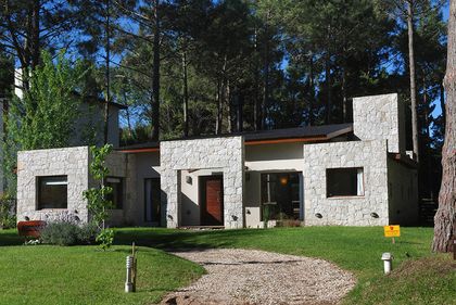 fachada moderna de piedra en bosque — proyecto Casa Cariló 2006, por Hugo Zawadski Arquitectos, en Cariló