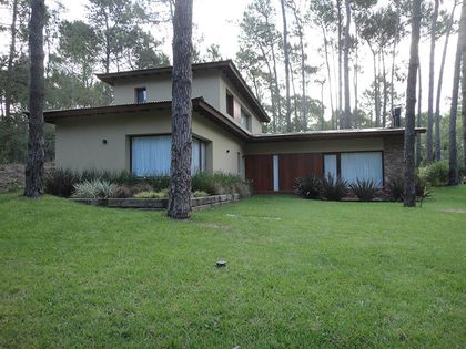 Fachada moderna en bosque con grandes ventanales — proyecto Casa Cariló 2015, por Hugo Zawadski Arquitectos, en Cariló