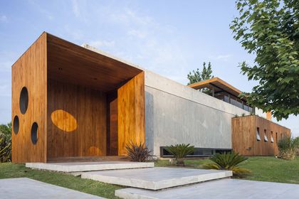 fachada moderna de casa con revestimiento de madera y hormigón — proyecto Santa Isabel, por Arfuso Arquitectos, en Ingeniero Maschwitz