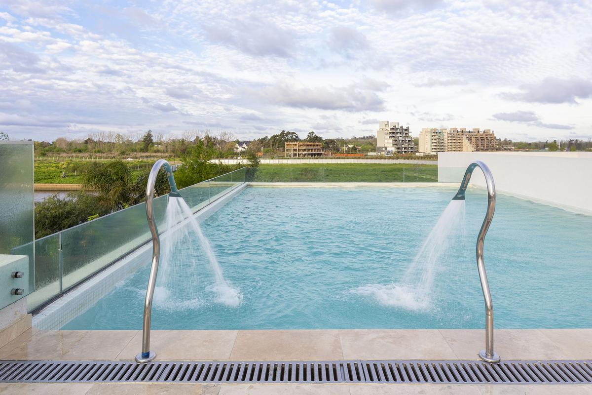 piscina infinita moderna com jatos d'água e vista rural — projeto Las Caletas, por Arfuso Arquitectos, em Nordelta