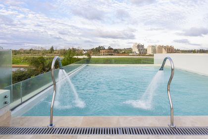 piscina infinita moderna con chorros de agua y vistas al campo — proyecto Las Caletas, por Arfuso Arquitectos, en Nordelta