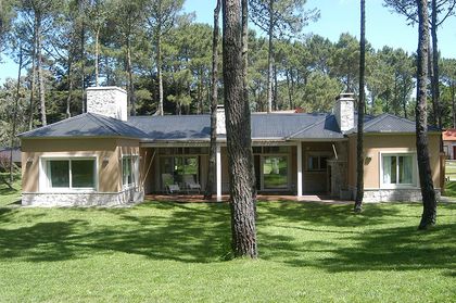 Fachada moderna de casa residencial rodeada de bosque — proyecto Casa Cariló 2005, por Hugo Zawadski Arquitectos, en Cariló
