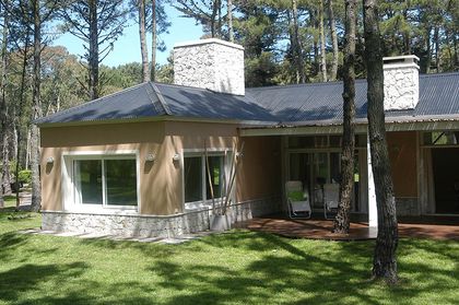 Casa moderna de dos pisos rodeada de árboles — proyecto Casa Cariló 2005, por Hugo Zawadski Arquitectos, en Cariló