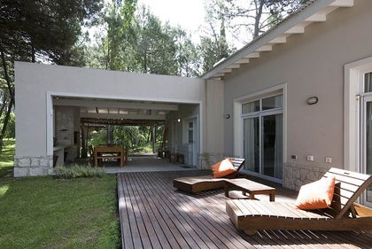 Patio moderno con deck de madera y vegetación exuberante — proyecto Casa Cariló 2007, por Hugo Zawadski Arquitectos, en Cariló