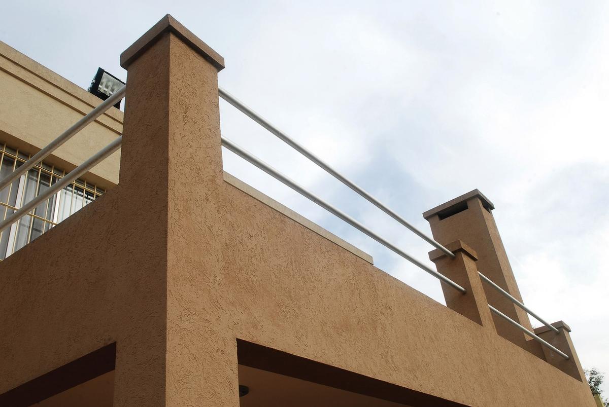 varanda moderna com guarda-corpo metálico e revestimento texturizado — projeto Casa El Recodo, por Fhee Construcciones, em Garin