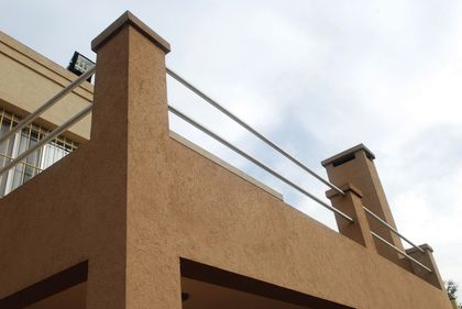 balcón moderno con baranda metálica y revestimiento texturado — proyecto Casa El Recodo, por Fhee Construcciones, en Garin