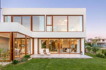 Fachada moderna con grandes ventanales y detalles en madera — proyecto Casa ME, por Estudio GR, en City Bell
