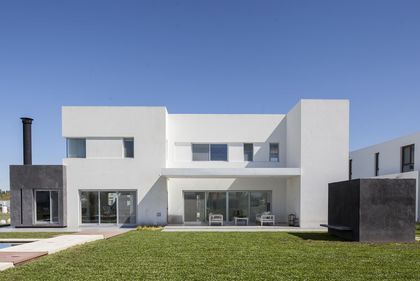 fachada moderna con ventanas amplias y detalles en metal negro — proyecto Casa FA, por Estudio GR, en City Bell