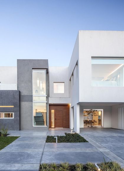 Fachada moderna de casa con volúmenes geométricos y grandes ventanales — proyecto Casa FA, por Estudio GR, en City Bell