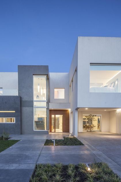 Casa moderna con volumenes de hormigón y madera, entrada vidriada — proyecto Casa FA, por Estudio GR, en City Bell