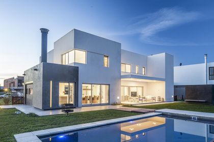 Fachada moderna con piscina e iluminación nocturna — proyecto Casa FA, por Estudio GR, en City Bell