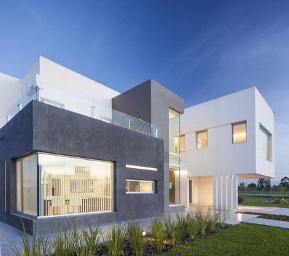 Fachada moderna con volúmenes geométricos y grandes ventanales — proyecto Casa FA, por Estudio GR, en City Bell