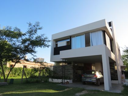 fachada moderna de casa con grandes ventanales y volúmenes geométricos — proyecto Casa GT- Barrio Los Arenales, por Olivieri Arquitectura, en Ingeniero Maschwitz