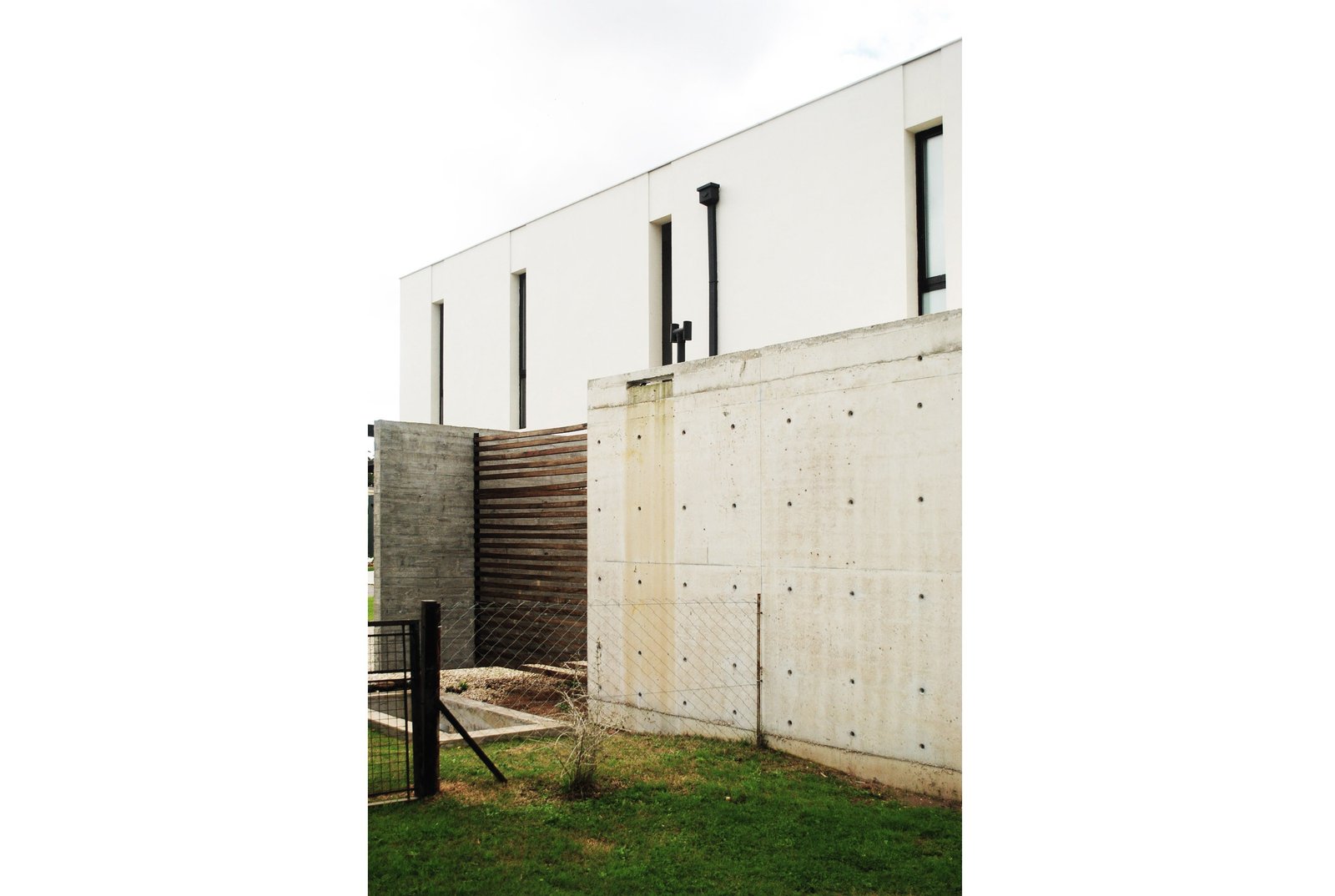 fachada moderna com concreto e madeira — projeto casa s, por GARAGE arquitectura, em Rumencó