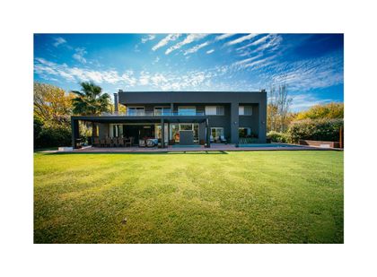 Fachada moderna con piscina y jardín exuberante — proyecto Grand Bell 98, por Mercedes  klappenbach, en City Bell