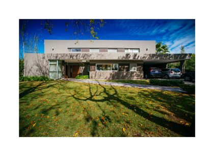 fachada moderna con ventanales y jardín exuberante — proyecto Grand Bell 98, por Mercedes  klappenbach, en City Bell