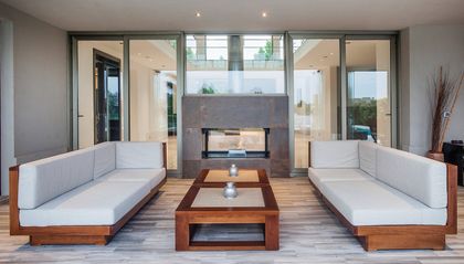 Living moderno semi-exterior con chimenea y grandes ventanales — proyecto Casa MSC, por Estudio Gamboa