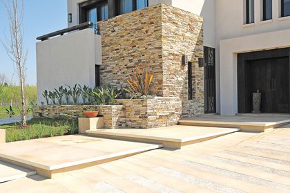 Fachada moderna con piedra, escalones y vegetación — proyecto Casa Tigre, por Estudio Gamboa, en Tigre