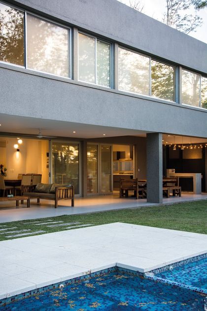 Casa moderna con pileta azul y terraza iluminada al atardecer — proyecto Casa 18, por Parrado Arquitectura