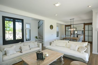 Living minimalista con sofás blancos y escales de caracol integrada — proyecto Casa 16, por Parrado Arquitectura