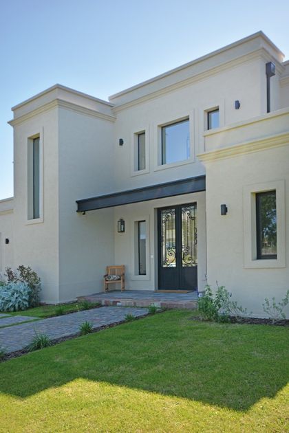 Casa contemporánea blanca con fachada geométrica y acceso principal destacado — proyecto Casa 16, por Parrado Arquitectura
