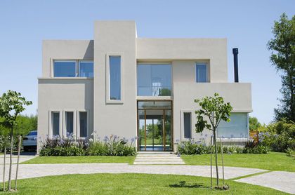 Casa minimalista blanca con fachada limpia y amplio jardín verde — proyecto Casa 13, por Parrado Arquitectura