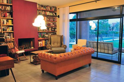 living contemporaneo con sofa terracota, hogar y ventanal a pileta — proyecto Casa 10, por Parrado Arquitectura
