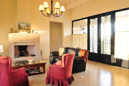 Living clásico con hogar, sillones rojos y puertas francesas negras — proyecto Casa 8, por Parrado Arquitectura