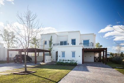 Casa moderna blanca con pergola de madera y jardín minimalista — proyecto TRV 165, por Estudio Arq Daniel Tarrio