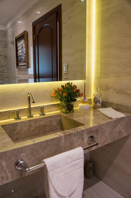 Baño moderno con mesada de mármol, espejo iluminado y flores — proyecto TRV 164, por Estudio Arq Daniel Tarrio