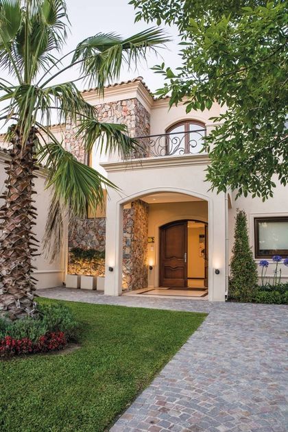 Fachada moderna de estilo mediterraneo con portada de madera y detalles en piedra — proyecto TRV 164, por Estudio Arq Daniel Tarrio