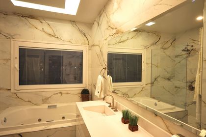 Bano moderno con marmol travertino, doble lavabo y banera — proyecto TRV 251, por Estudio Arq Daniel Tarrio