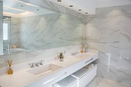 Bano minimalista con mesada doble en marmol blanco y espejo — proyecto TRL 9, por Estudio Arq Daniel Tarrio