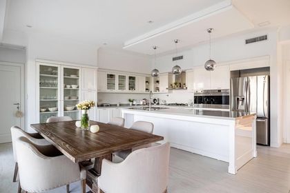 Cocina blanca minimalista con isla de mármol y muebles de madera — proyecto TRV 153, por Estudio Arq Daniel Tarrio