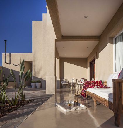 Terraza cubierta moderna con piso hormigonado, plantas y flores rojas — proyecto TRV 137, por Estudio Arq Daniel Tarrio