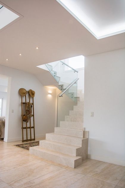 Escalera de hormigón con barandal vidrio y doble altura iluminada — proyecto TRV 620, por Estudio Arq Daniel Tarrio