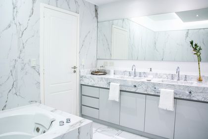 Baño moderno con mármol Carrara, mesada doble y espejo empotrado — proyecto TRV 620, por Estudio Arq Daniel Tarrio