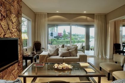 Living contemporáneo con vista panorámica, chimenea y ventanales — proyecto Altamira del Lago, por Marconi Silva Arquitectos, en Tigre