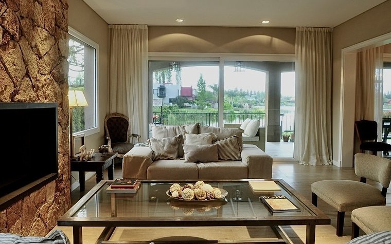 Living con ventanales y muebles de madera, proyecto de Marconi Silva Arquitectos