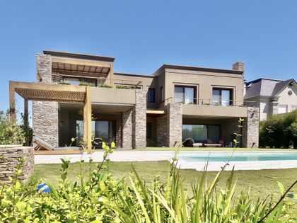 Casa contemporánea de dos plantas con pileta y jardín verde frontal — proyecto Golf Club Nordelta, por Marconi Silva Arquitectos, en Nordelta