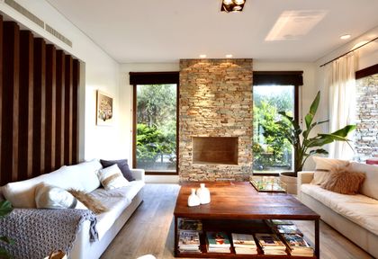 Living moderno con hogar ladrillo visto y amplios ventanales verdes — proyecto Golf Club Nordelta, por Marconi Silva Arquitectos, en Nordelta
