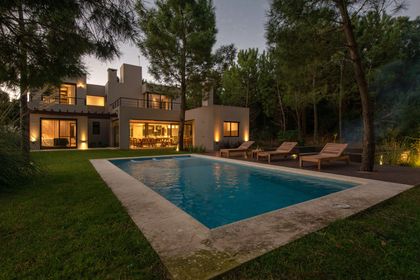 casa moderna con piscina iluminada y rodeada de vegetación — proyecto Costa Esmeralda 1, por Arquitecto Caceres, en Costa Esmeralda