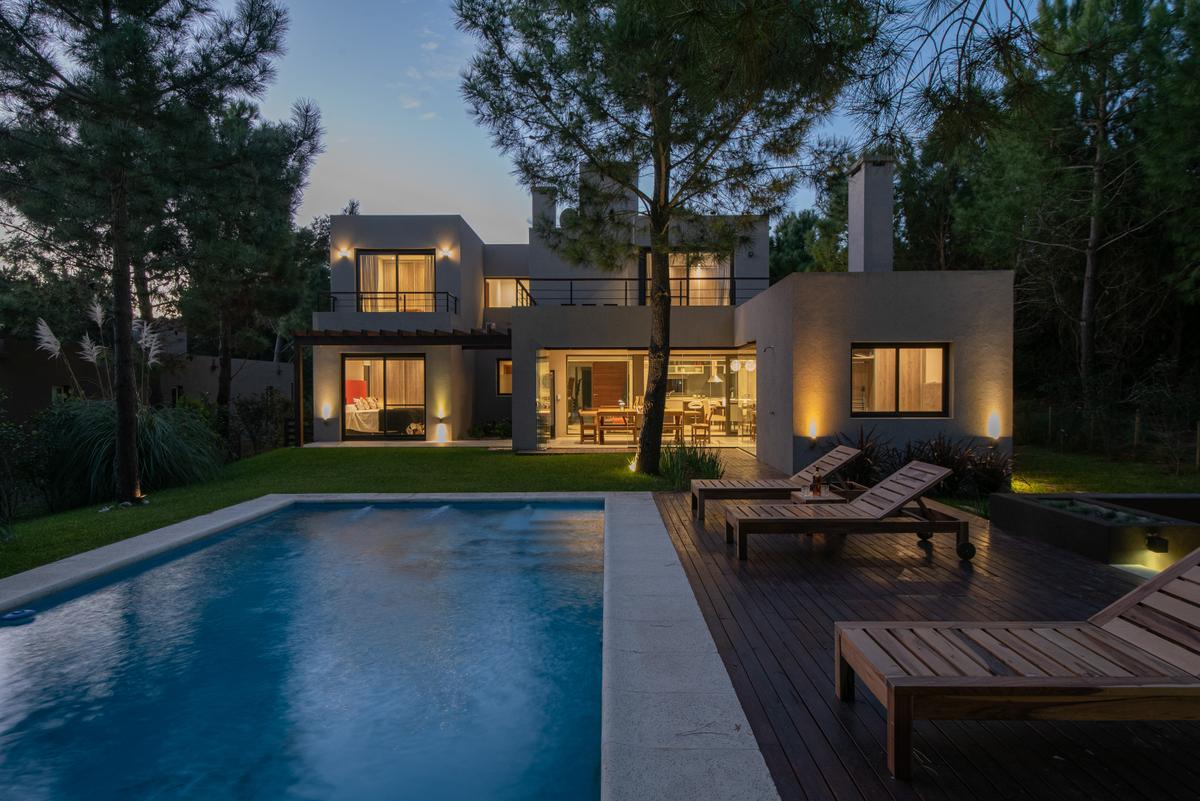 Casa moderna con piscina y deck de madera, rodeada de vegetación — proyecto Costa Esmeralda 1, por Arquitecto Caceres, en Costa Esmeralda
