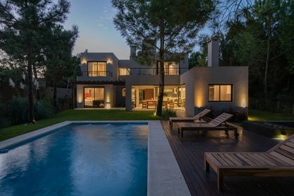 Casa moderna con piscina y deck de madera, rodeada de vegetación — proyecto Costa Esmeralda 1, por Arquitecto Caceres, en Costa Esmeralda