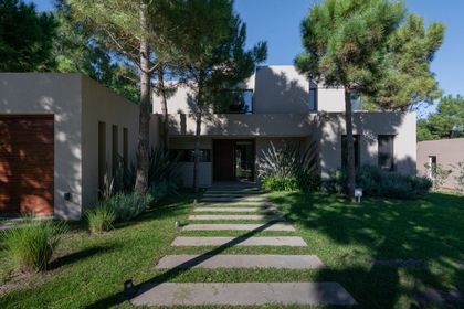 fachada moderna con concreto beige y camino de piedra — proyecto Costa Esmeralda 1, por Arquitecto Caceres, en Costa Esmeralda