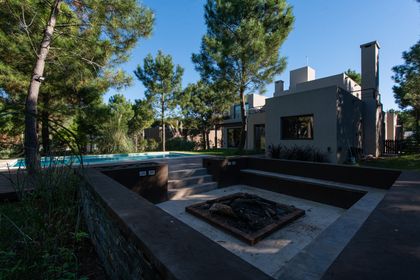 Amplio deck de madera con piscina y fogonero moderno — proyecto Costa Esmeralda 1, por Arquitecto Caceres, en Costa Esmeralda