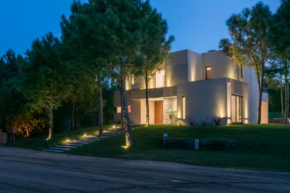 fachada moderna curva con iluminación cálida — proyecto Costa Esmeralda 2, por Arquitecto Caceres, en Costa Esmeralda