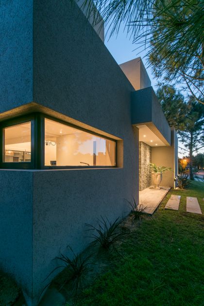 Fachada moderna con ventana alargada y detalles de piedra — proyecto Costa Esmeralda 2, por Arquitecto Caceres, en Costa Esmeralda