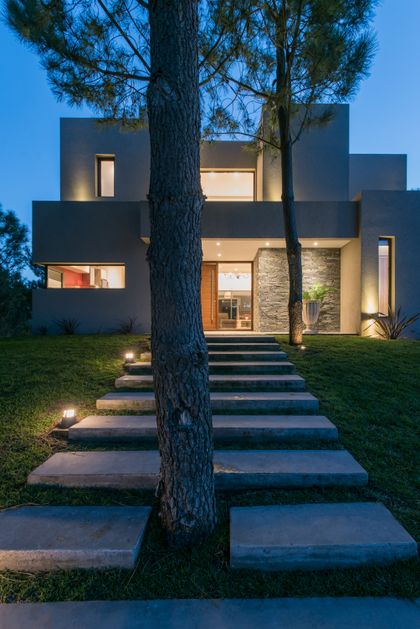 Fachada moderna con escalones de hormigón flotantes e iluminación integrada — proyecto Costa Esmeralda 2, por Arquitecto Caceres, en Costa Esmeralda